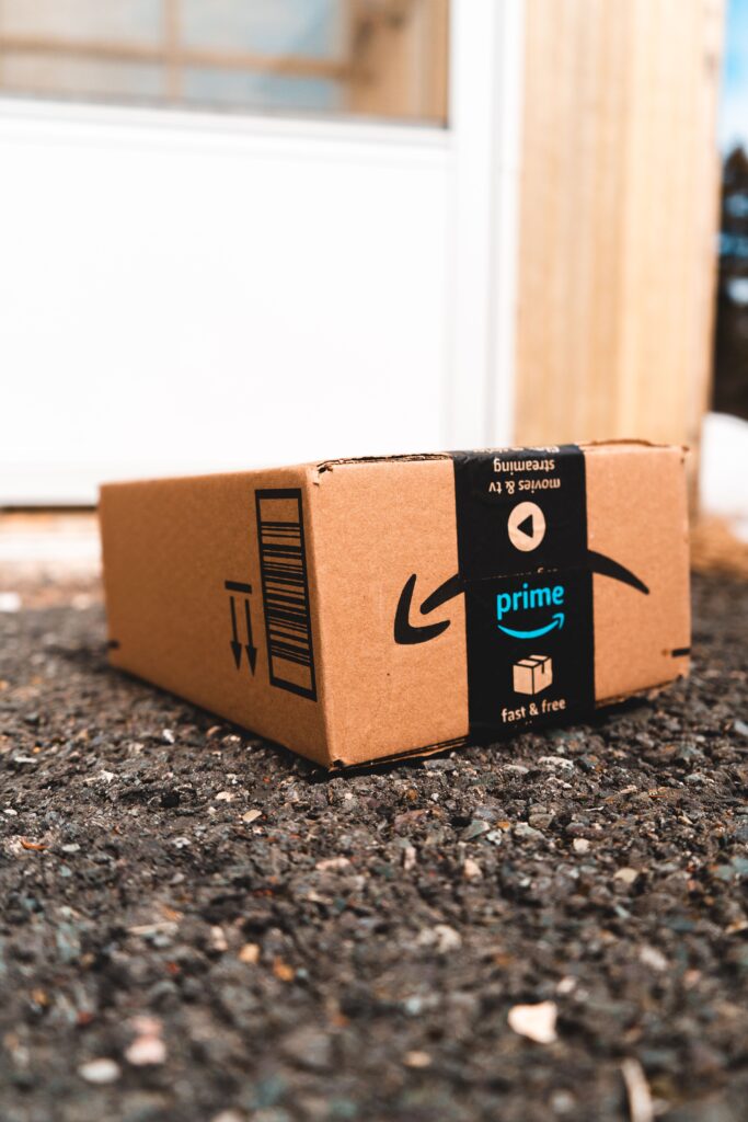 Amazon best seler A cardboard box marked with Prime logo placed outside on a porch, ready for delivery.