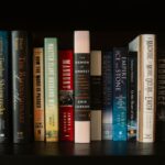 An array of colorful books lined up on a bookshelf with diverse themes and authors.