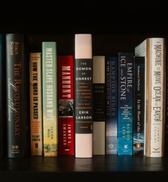An array of colorful books lined up on a bookshelf with diverse themes and authors.